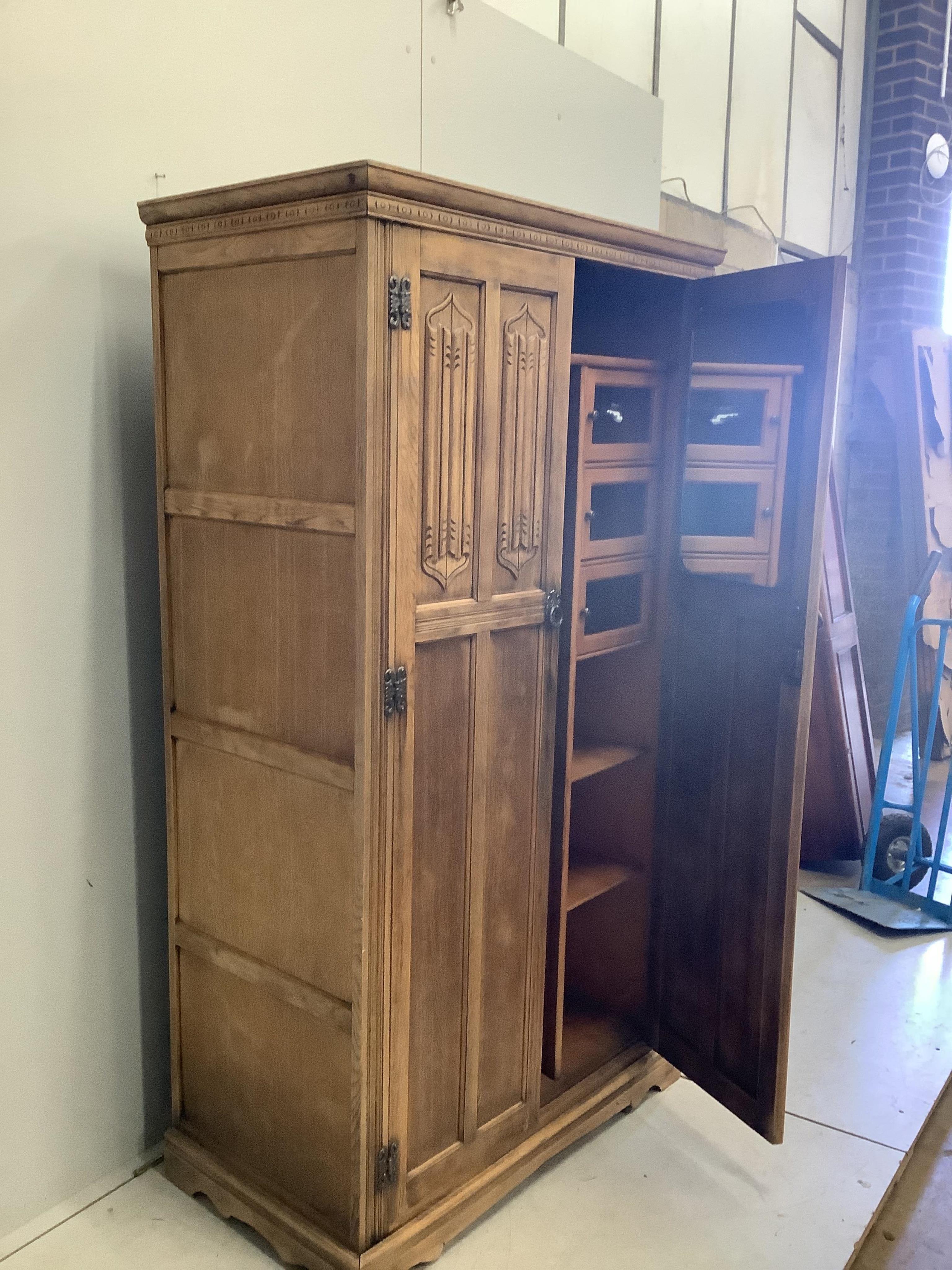 An early 20th century oak linenfold moulded oak compactum wardrobe, width 96cm, depth 53cm, height 174cm. Condition - fair